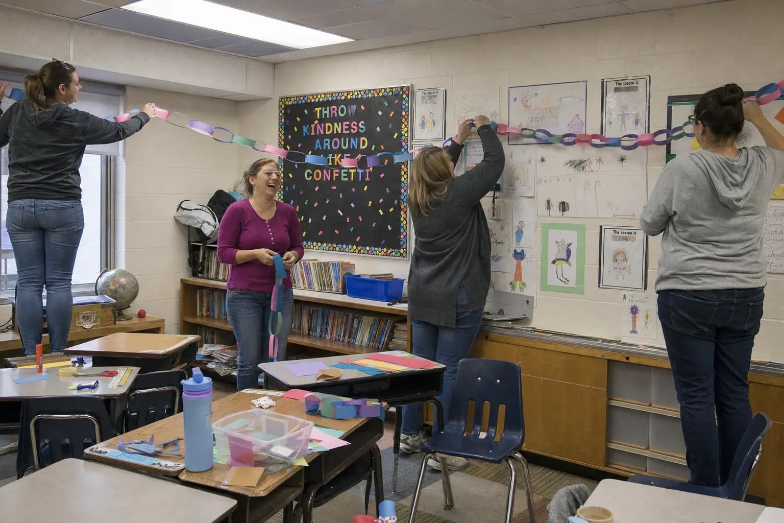 Parents and a teacher decorating a classroom together
